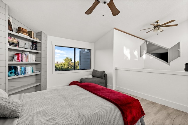 bedroom featuring ceiling fan, light hardwood / wood-style floors, and vaulted ceiling