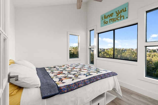 bedroom featuring ceiling fan, vaulted ceiling, and light wood-type flooring