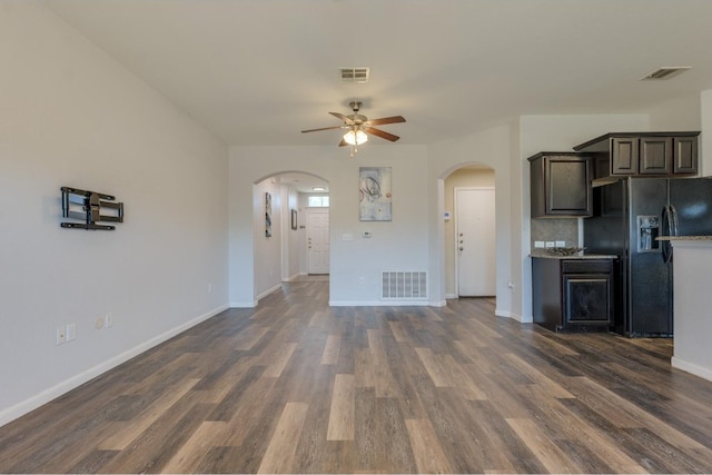 kitchen featuring dark brown cabinetry, ceiling fan, dark hardwood / wood-style floors, backsplash, and black fridge with ice dispenser