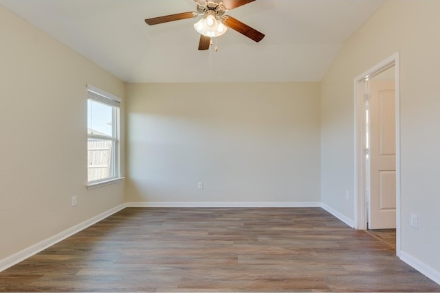 spare room with ceiling fan, lofted ceiling, and dark wood-type flooring