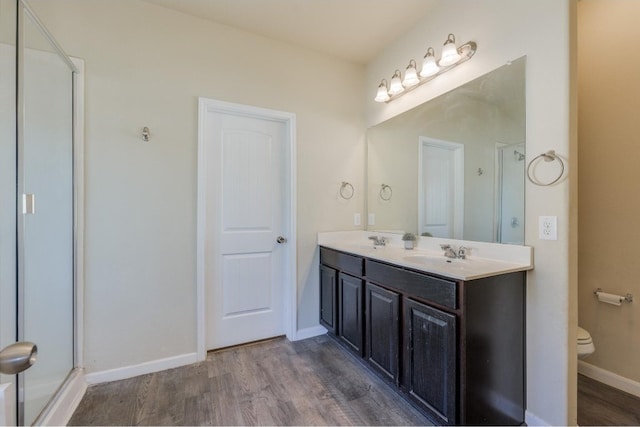 bathroom with toilet, vanity, and hardwood / wood-style flooring