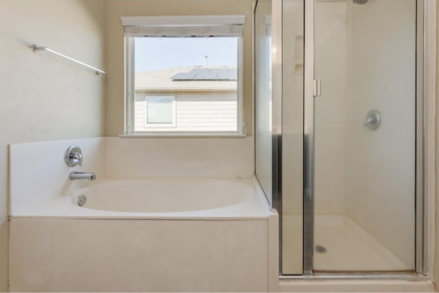 bathroom featuring shower with separate bathtub