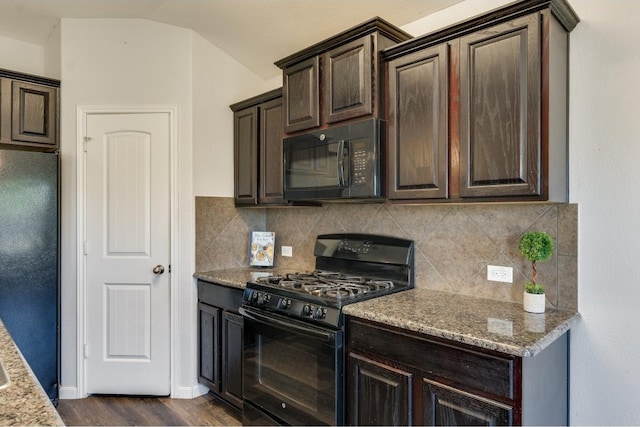 kitchen with tasteful backsplash, light stone counters, black appliances, and vaulted ceiling