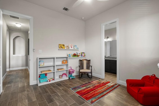 game room with ceiling fan and dark hardwood / wood-style flooring