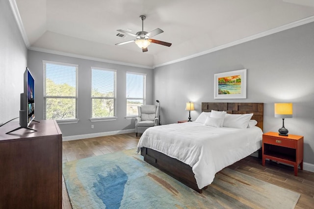 bedroom featuring a tray ceiling, ceiling fan, crown molding, and wood-type flooring