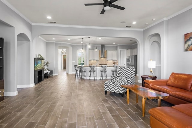 living room with ceiling fan, sink, dark hardwood / wood-style floors, and ornamental molding