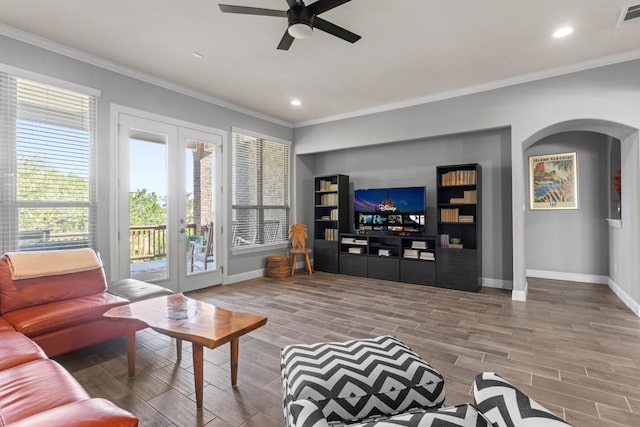 living room featuring hardwood / wood-style floors, ceiling fan, crown molding, and french doors