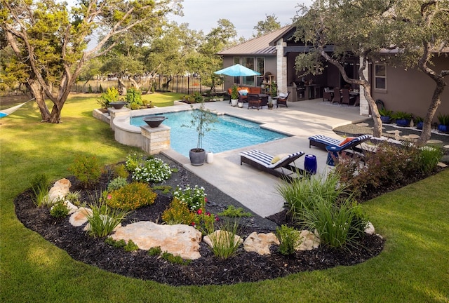 view of swimming pool with a yard, exterior kitchen, and a patio