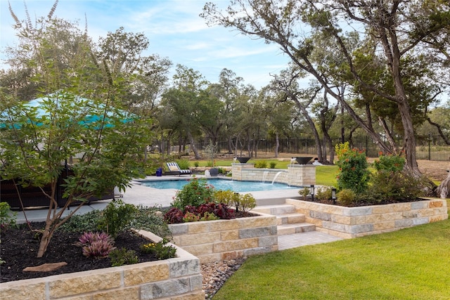 view of swimming pool featuring pool water feature and a lawn