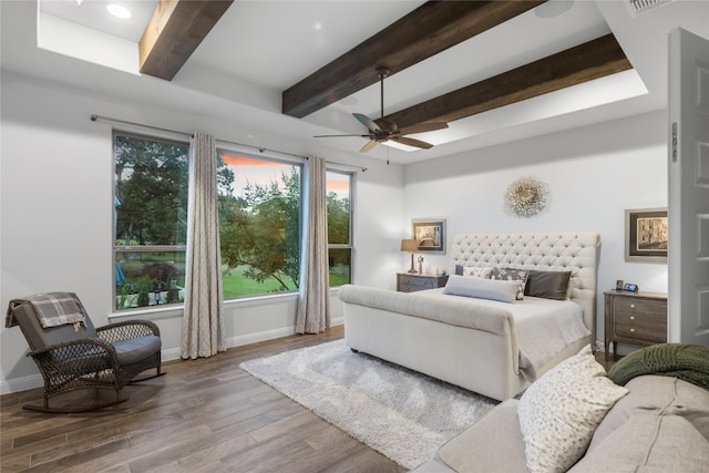 bedroom with beamed ceiling, hardwood / wood-style flooring, and ceiling fan