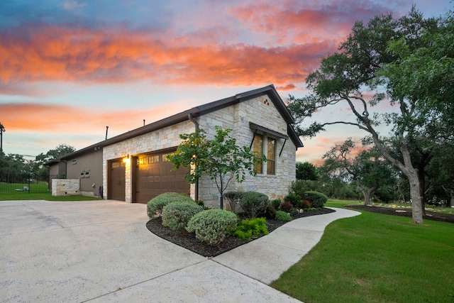 property exterior at dusk featuring a garage and a lawn