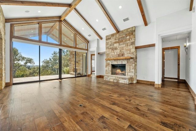 unfurnished living room with beamed ceiling, a stone fireplace, wood-type flooring, and high vaulted ceiling