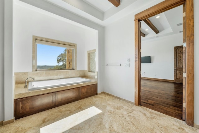 bathroom featuring a washtub, beamed ceiling, and hardwood / wood-style flooring