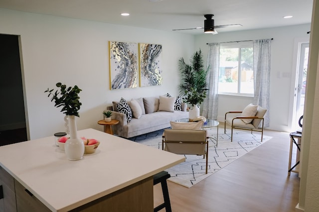 living room with ceiling fan and light hardwood / wood-style flooring