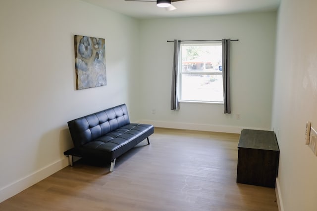 living area with ceiling fan and light hardwood / wood-style flooring