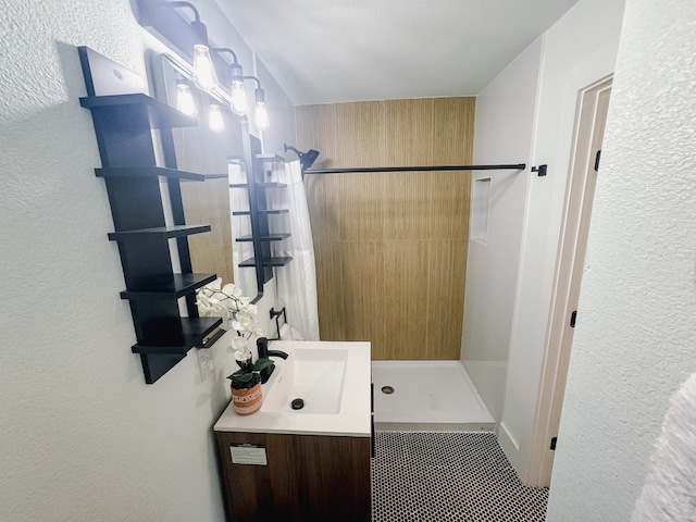 bathroom with vanity and a tile shower