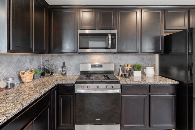 kitchen featuring dark brown cabinetry, stainless steel appliances, light stone counters, and backsplash