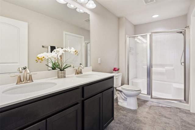 bathroom with tile patterned flooring, vanity, toilet, and a shower with shower door