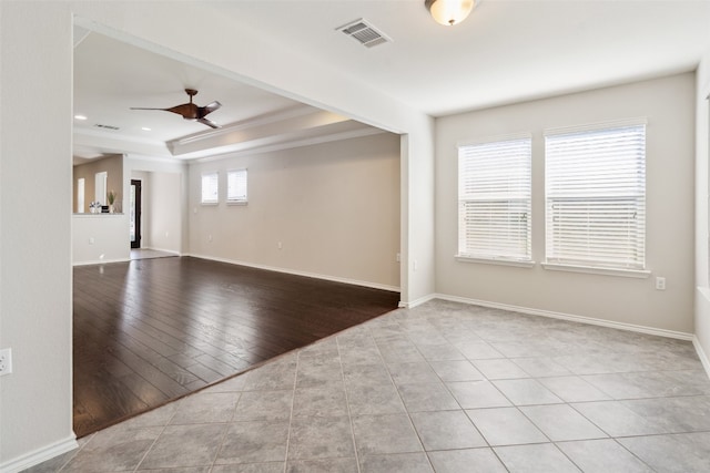 unfurnished room featuring ceiling fan, light wood-type flooring, ornamental molding, and a wealth of natural light