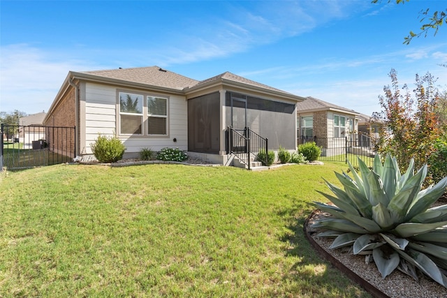 back of property featuring a sunroom and a yard