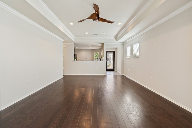 unfurnished living room with a raised ceiling, ceiling fan, dark hardwood / wood-style floors, and ornamental molding