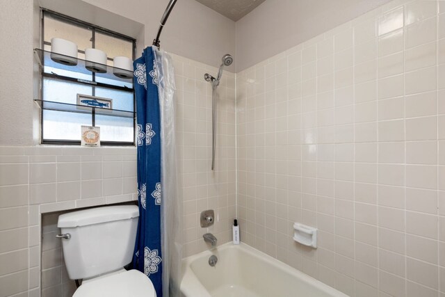 bathroom featuring shower / bath combination with curtain and toilet