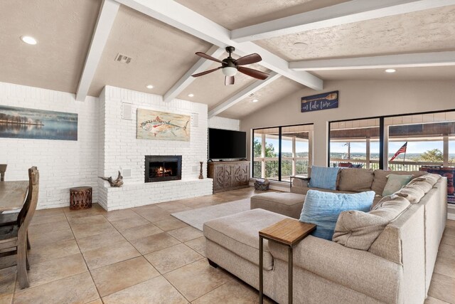 tiled living room featuring ceiling fan, a fireplace, lofted ceiling with beams, and a textured ceiling