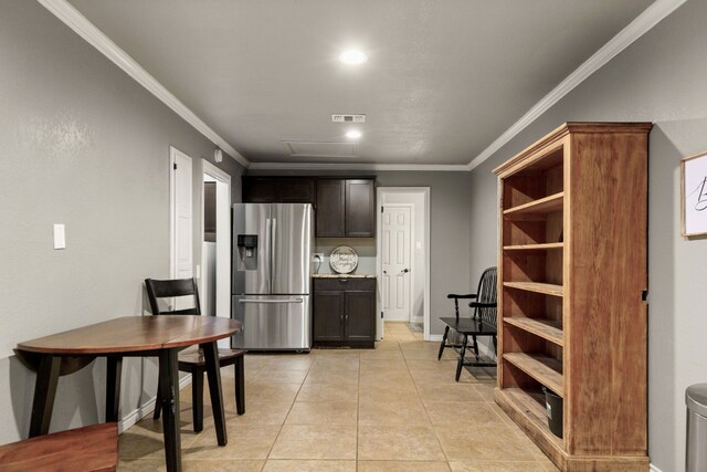 kitchen with dark brown cabinets, stainless steel fridge, light tile patterned flooring, and crown molding