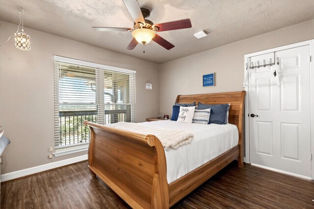 bedroom with a textured ceiling, dark hardwood / wood-style flooring, and ceiling fan