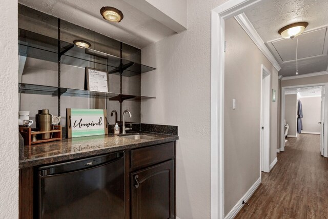 bar with ornamental molding, dark brown cabinetry, sink, hardwood / wood-style flooring, and black dishwasher