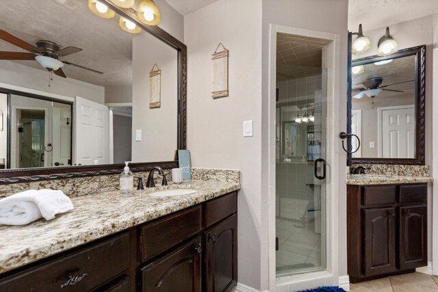 bathroom featuring tile patterned flooring, vanity, and a shower with door