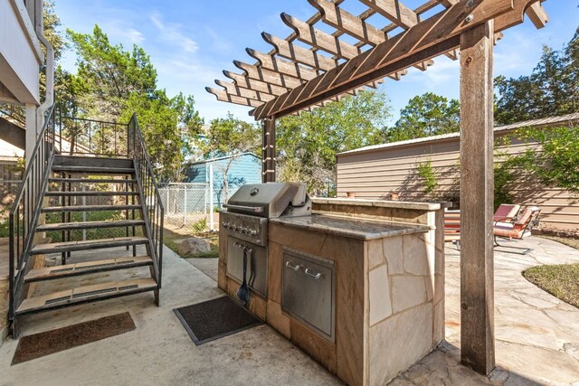 view of patio / terrace featuring a pergola, grilling area, and an outdoor kitchen