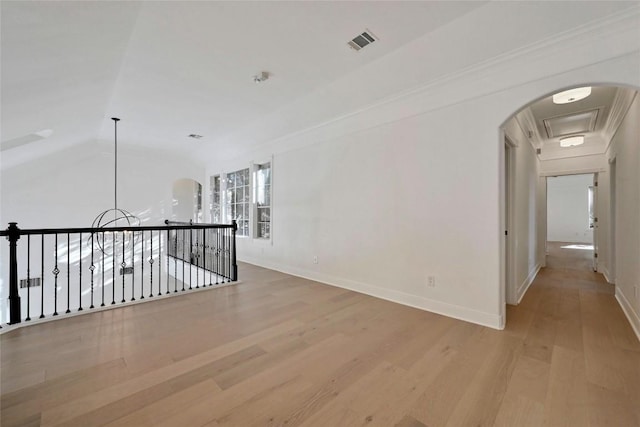 corridor featuring light hardwood / wood-style flooring, lofted ceiling, and ornamental molding