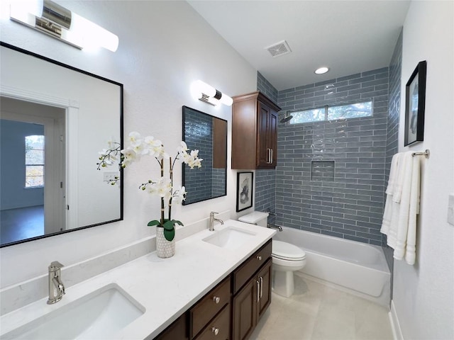 full bathroom with toilet, vanity, and tiled shower / bath