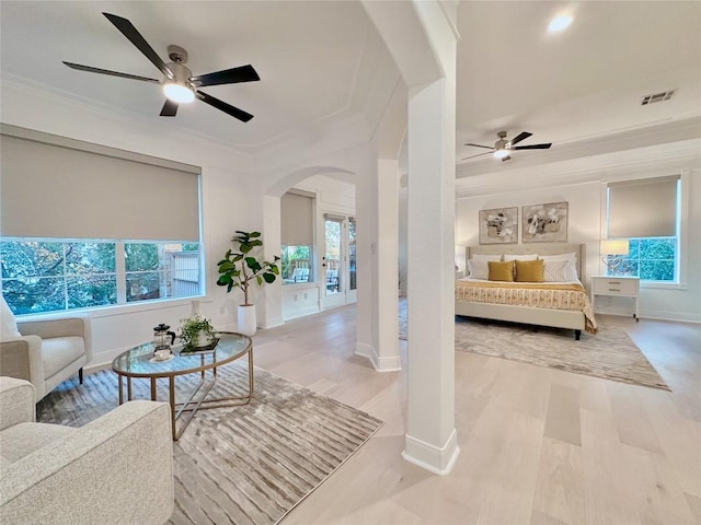 bedroom with light wood-type flooring, ceiling fan, and ornamental molding