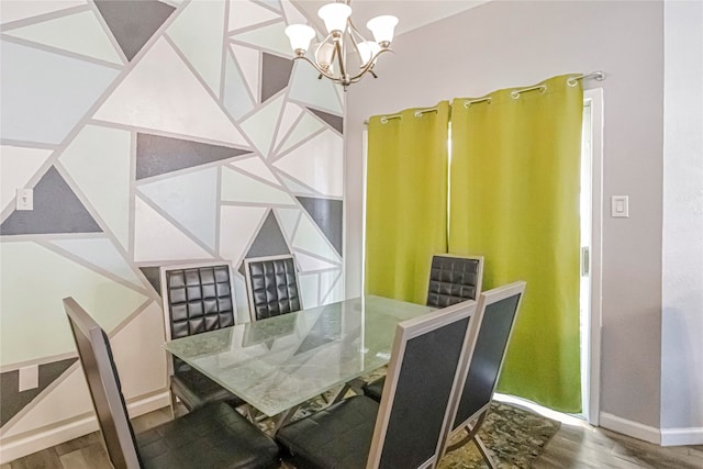 dining space with hardwood / wood-style floors and a notable chandelier