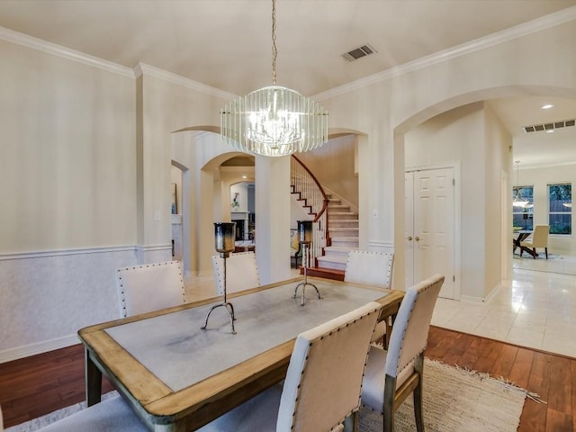 dining room with crown molding, wood-type flooring, and a chandelier