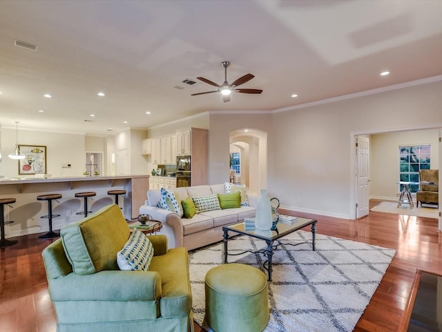 living room with crown molding, light hardwood / wood-style flooring, and ceiling fan