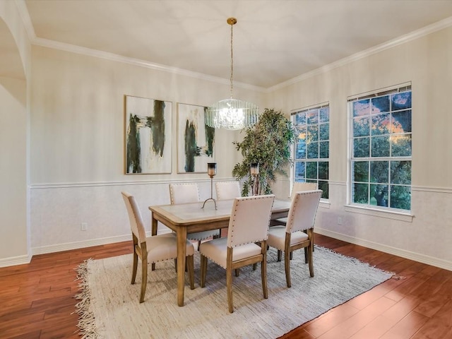 dining space with crown molding, wood-type flooring, and a chandelier