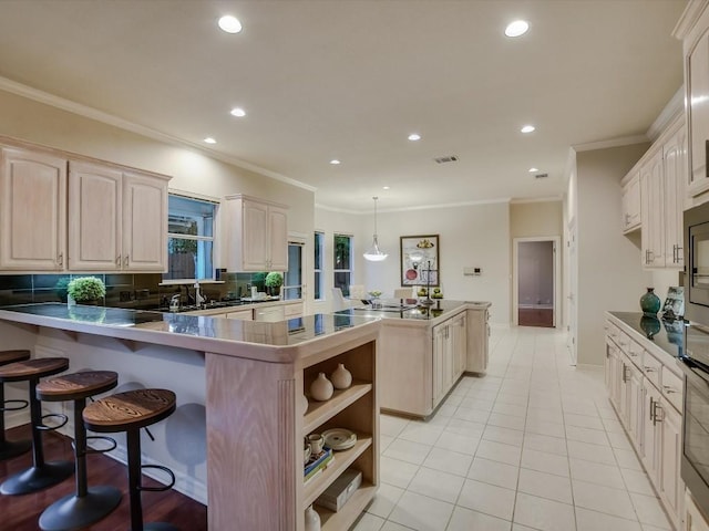 kitchen with light tile patterned floors, a breakfast bar, hanging light fixtures, decorative backsplash, and kitchen peninsula