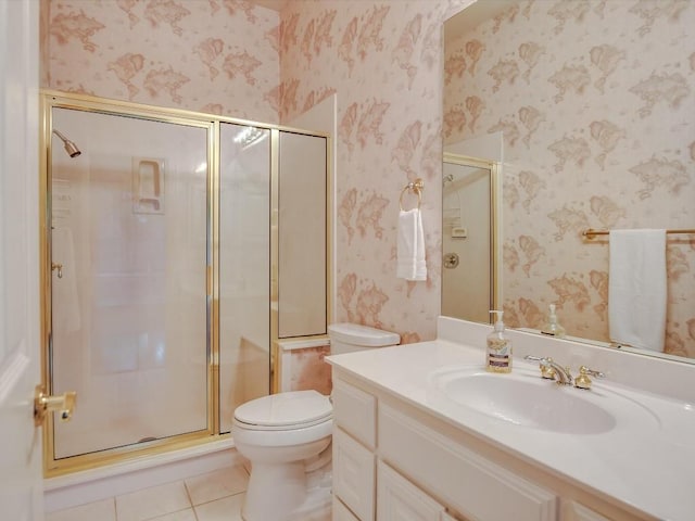 bathroom with tile patterned floors, toilet, a shower with shower door, and vanity