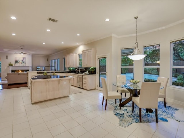 kitchen with hanging light fixtures, light tile patterned flooring, ornamental molding, and stainless steel dishwasher