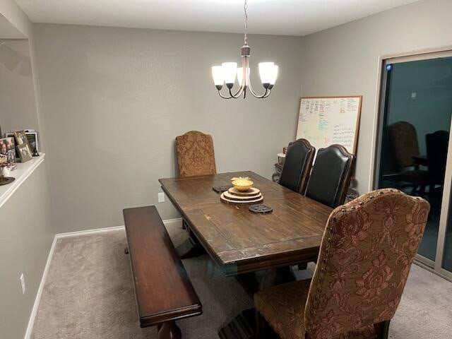 dining room with a notable chandelier and light colored carpet