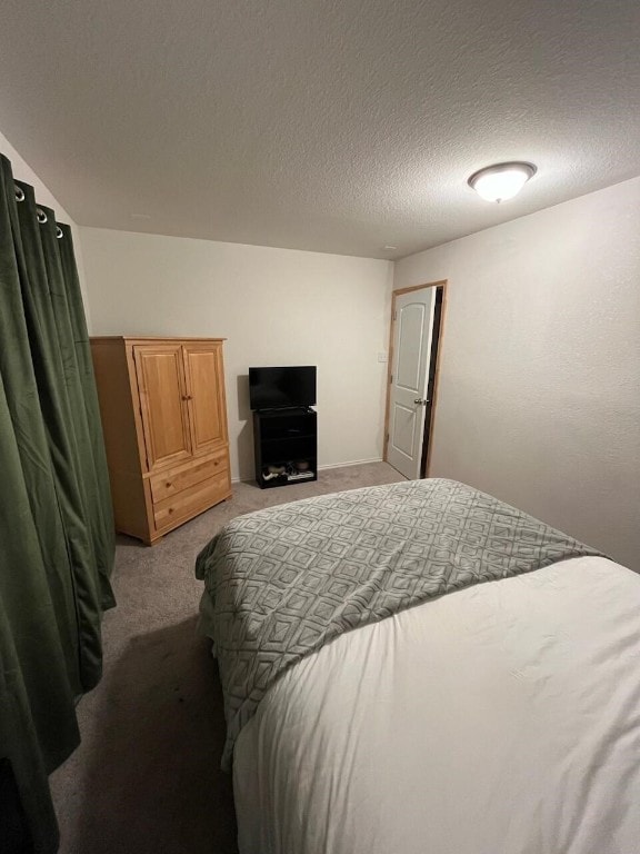 bedroom with a textured ceiling and light carpet