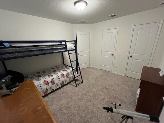 carpeted bedroom featuring a textured ceiling