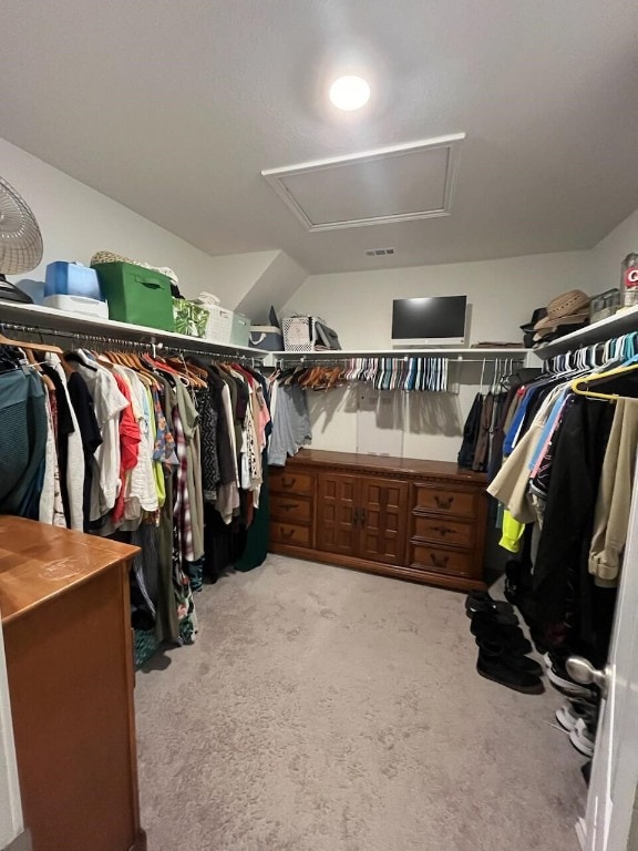 walk in closet featuring light colored carpet