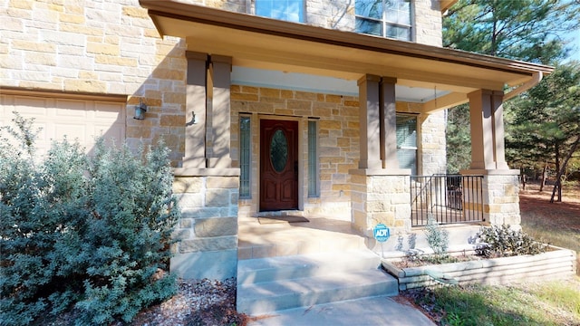 doorway to property featuring covered porch and a garage