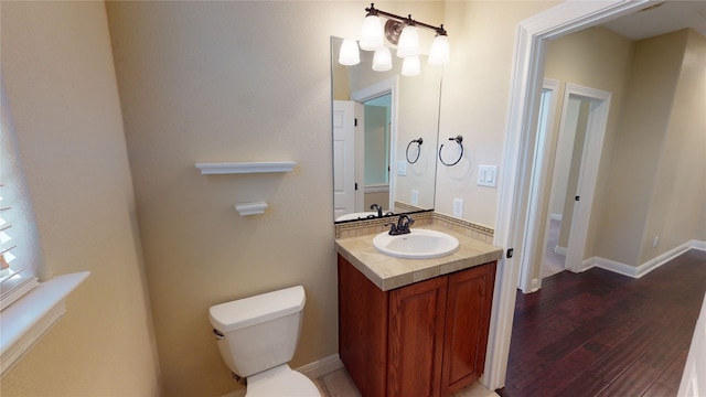 bathroom with hardwood / wood-style floors, vanity, and toilet