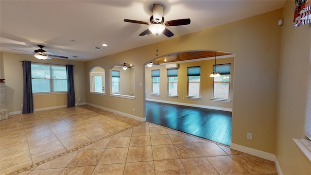 empty room with ceiling fan and light hardwood / wood-style flooring