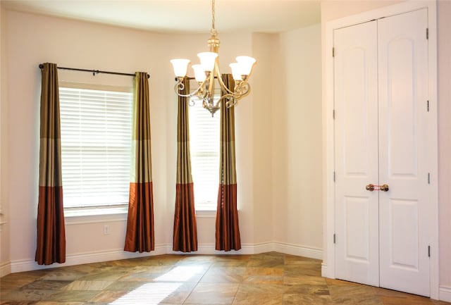 unfurnished room with a notable chandelier